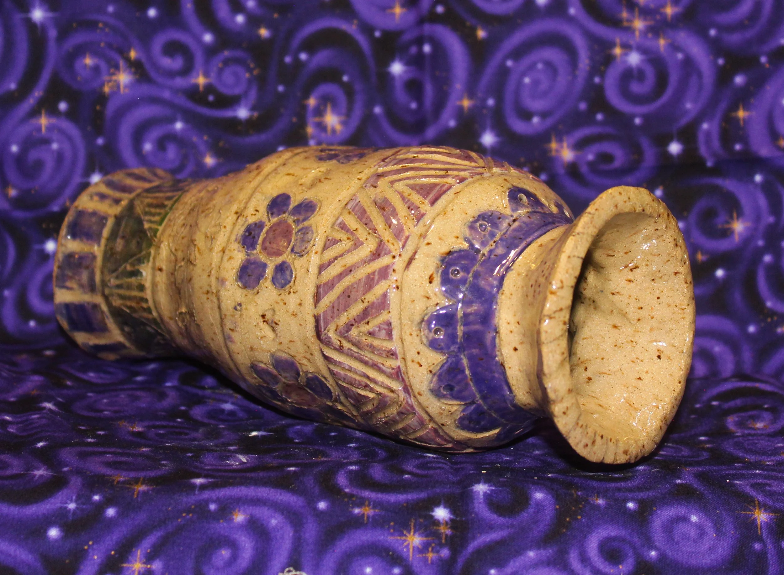 Speckled vase with purple pattersn and flowers. 