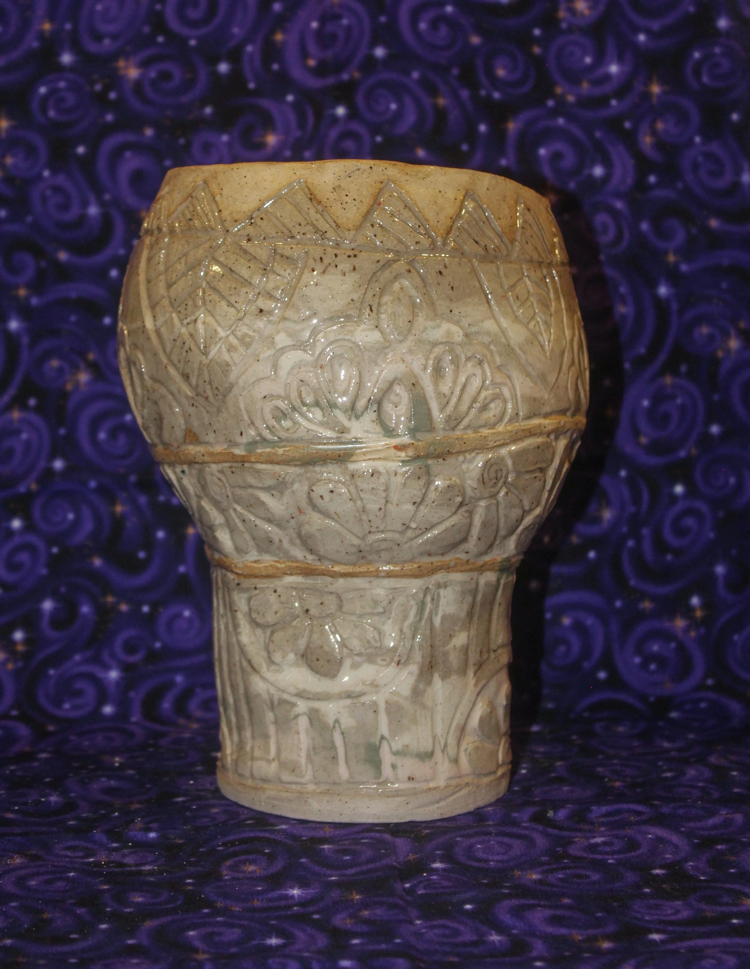 Marbled handbuilt vase with carved mandala patterns. 