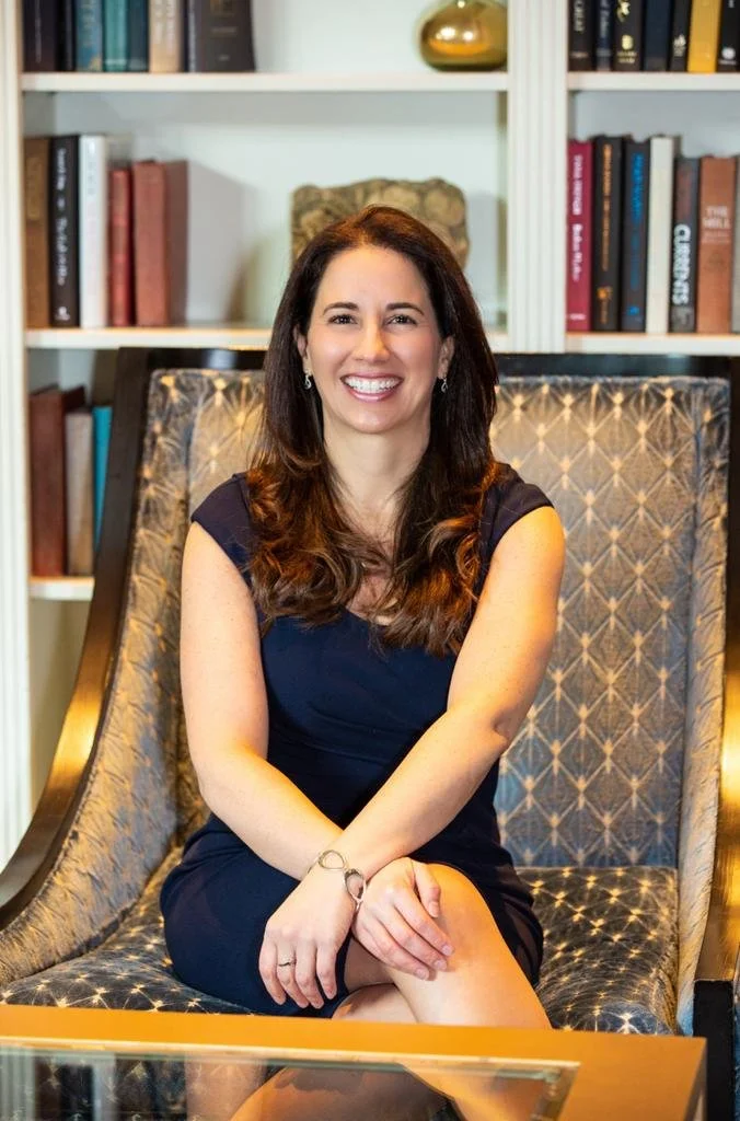 Dr. Isabel Pérez, biological and integrative dentist, sitting outdoors with a laptop, offering holistic consultations focused on oral health, emotions, and whole-body wellness.
