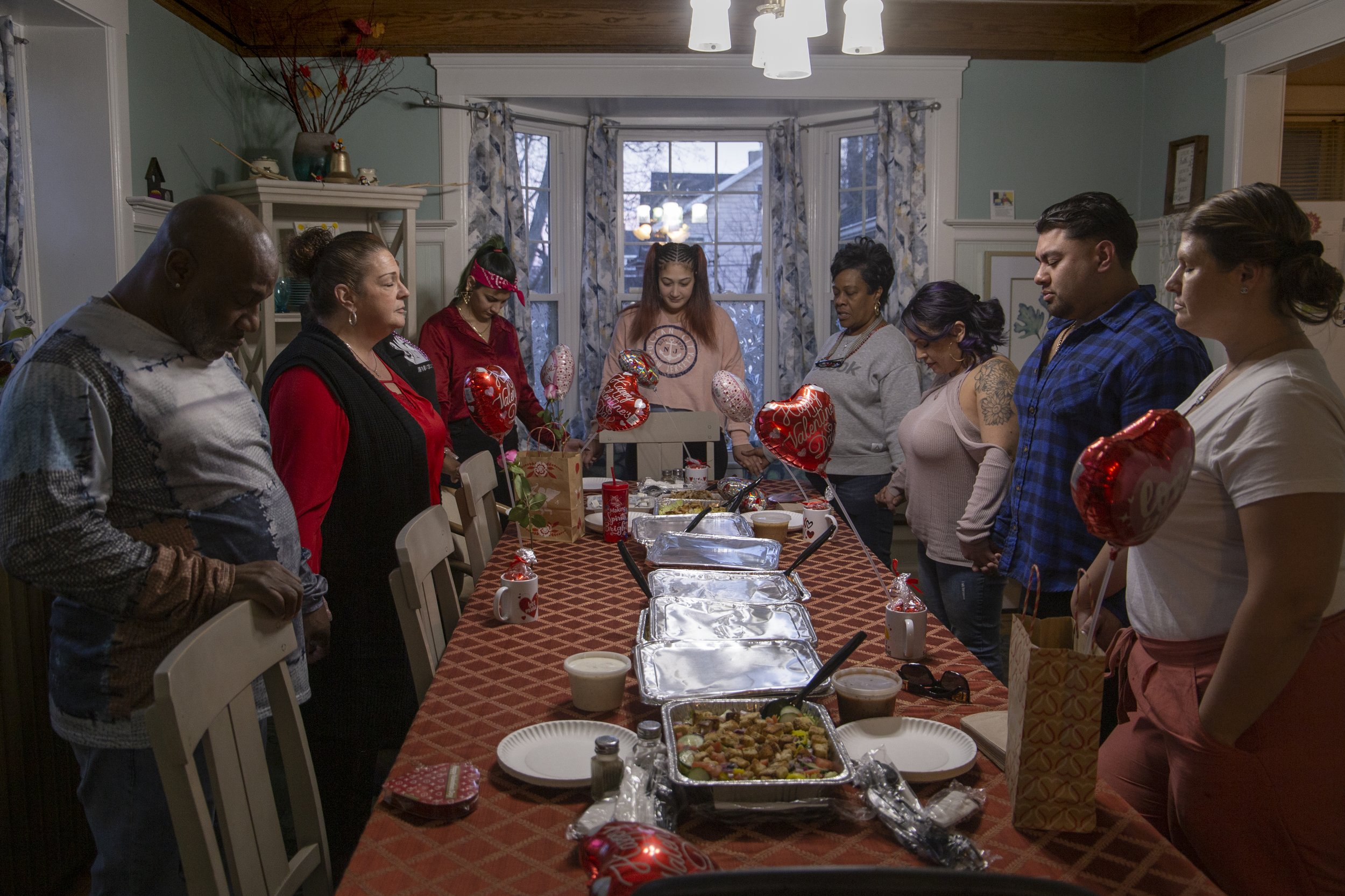 The ladies and organizers of The Jennifer House gather for a prayer before sharing dinner in Rochester, N.Y. on Feb. 14, 2024. The Jennifer House has been a sanctuary for women facing homelessness, fleeing domestic violence, justice involvement, and 