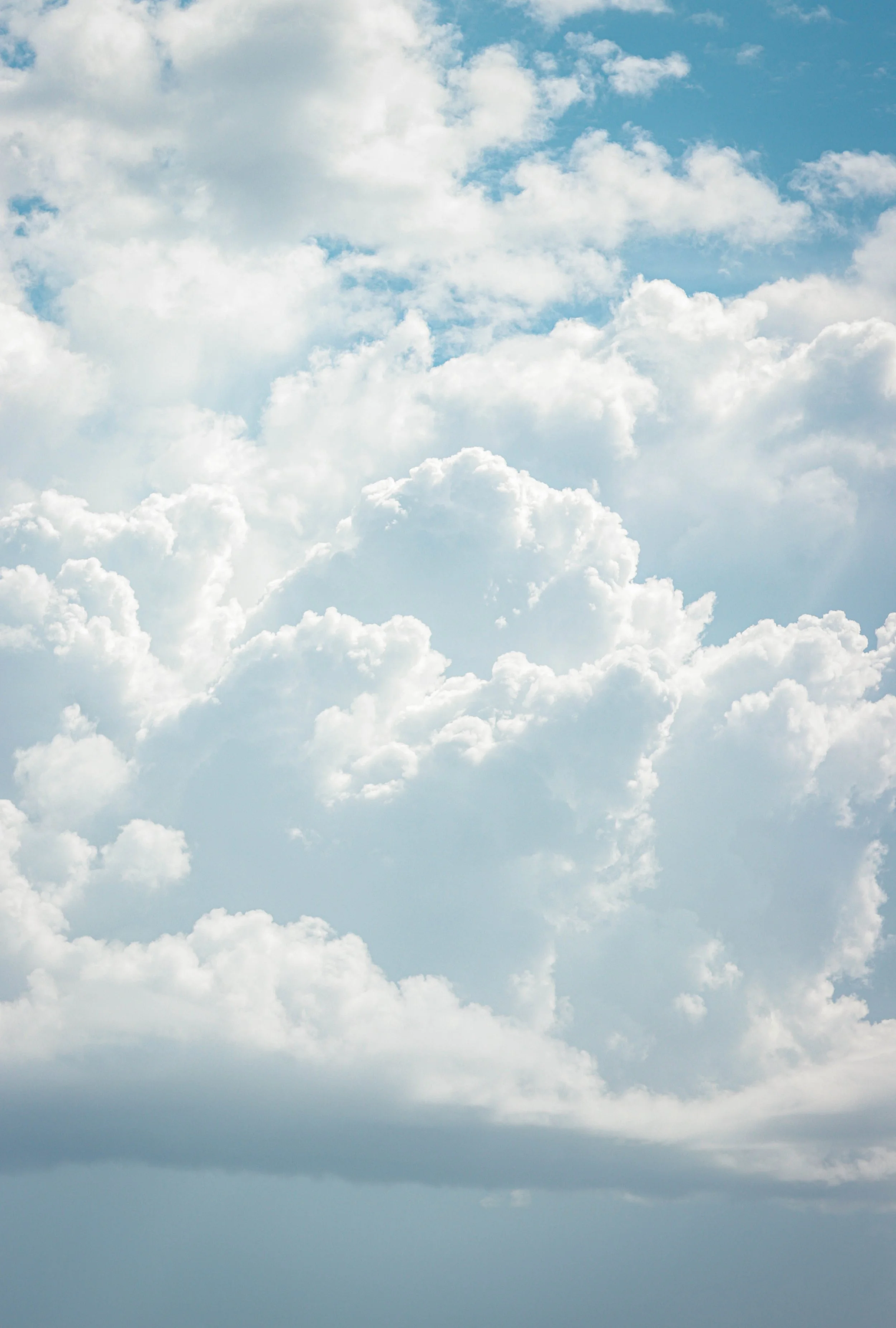 Cloudy sky with various white and gray clouds under a blue sky.