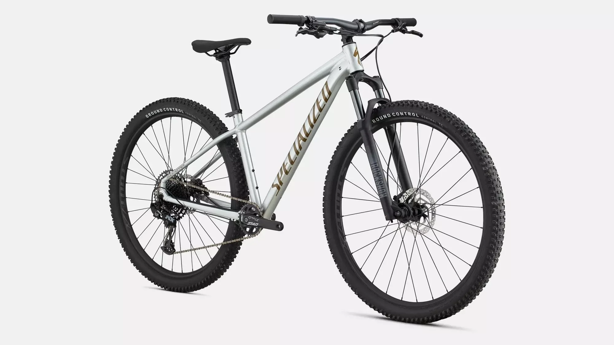 Silver and black 2026 SPECIALIZED ROCKHOPPER EXPERT mountain bike with knobby tires and front suspension, set against a plain gray background.