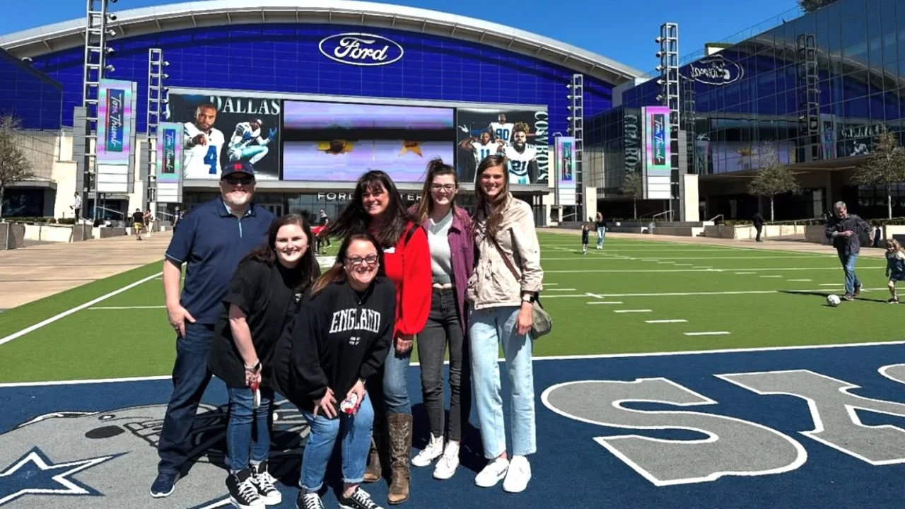 Group posing in front of football stadium entrance
