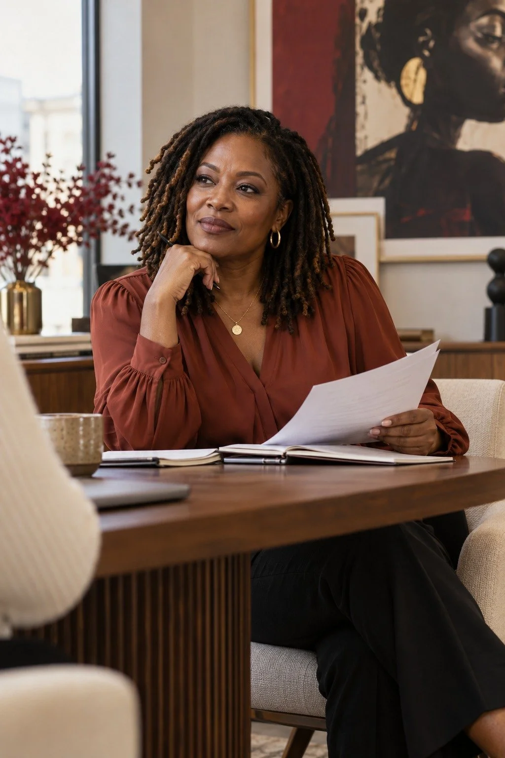 Black woman leader reviewing documents and considering a different approach.