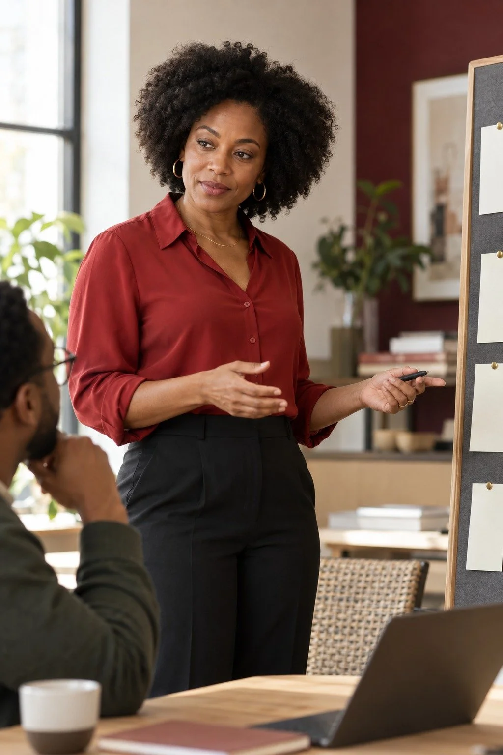 Black woman leader discussing a deliberate next step beside a planning board.