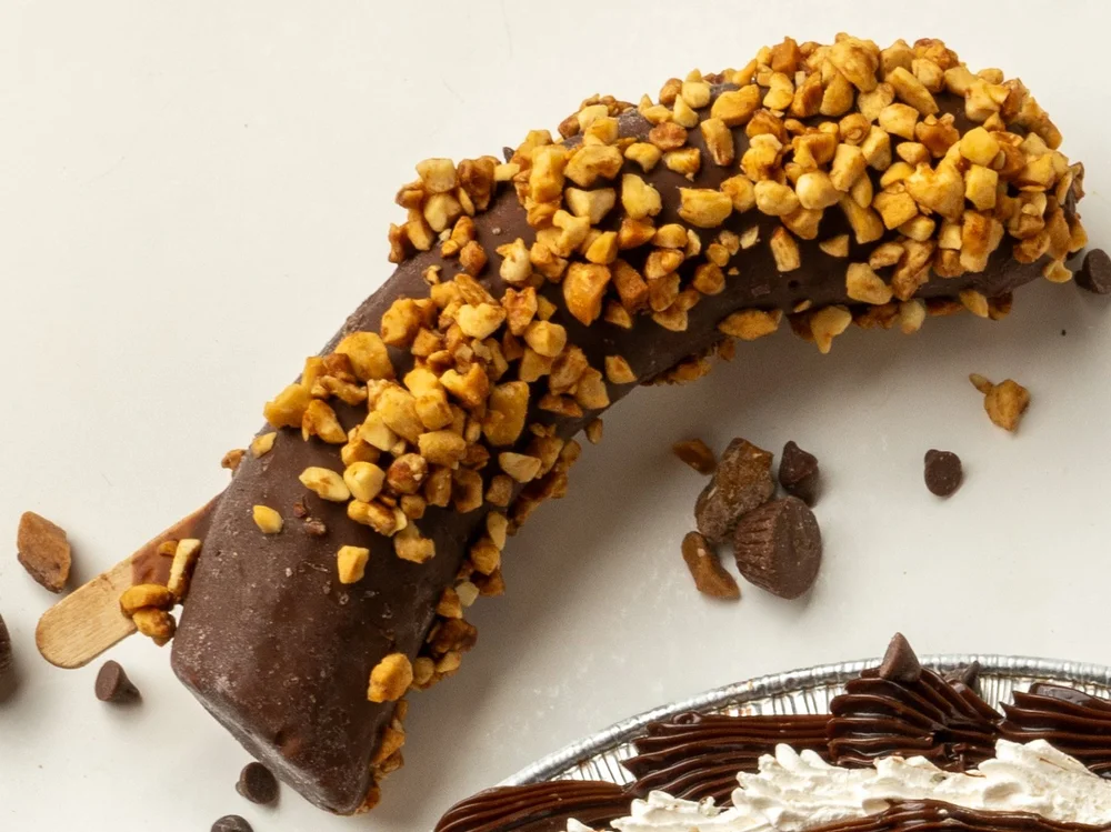 Chocolate-dipped banana on a stick rolled in chopped nuts at Merla-Mae Ice Cream in London, Ontario