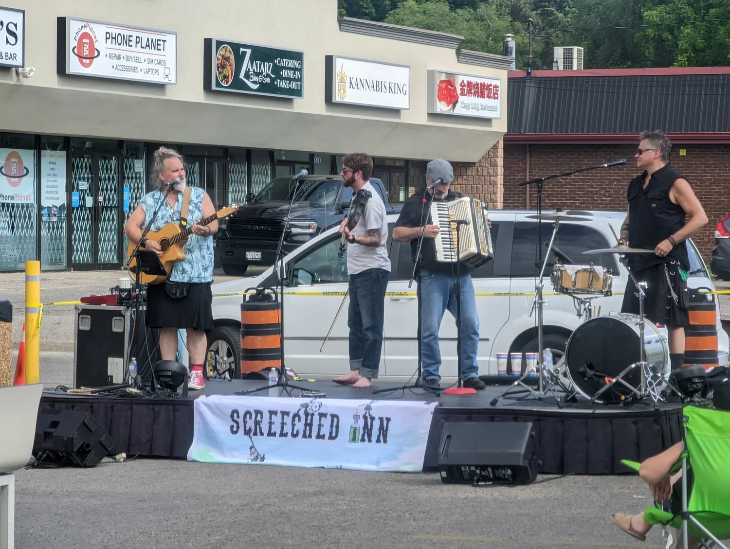 Screeched Inn playing guitar, fiddle, accordion and drums on the outdoor stage at Merla-Mae Ice Cream in London, Ontario