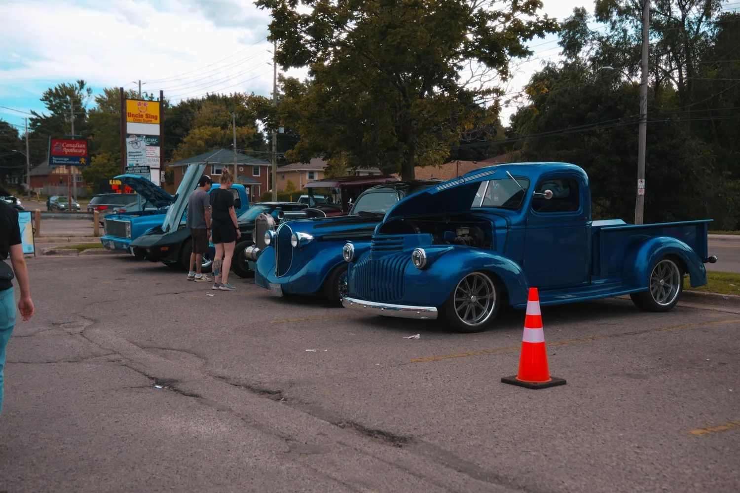 Row of classic cars and custom builds lined up along the lot at the Merla-Mae Car Show in London, Ontario
