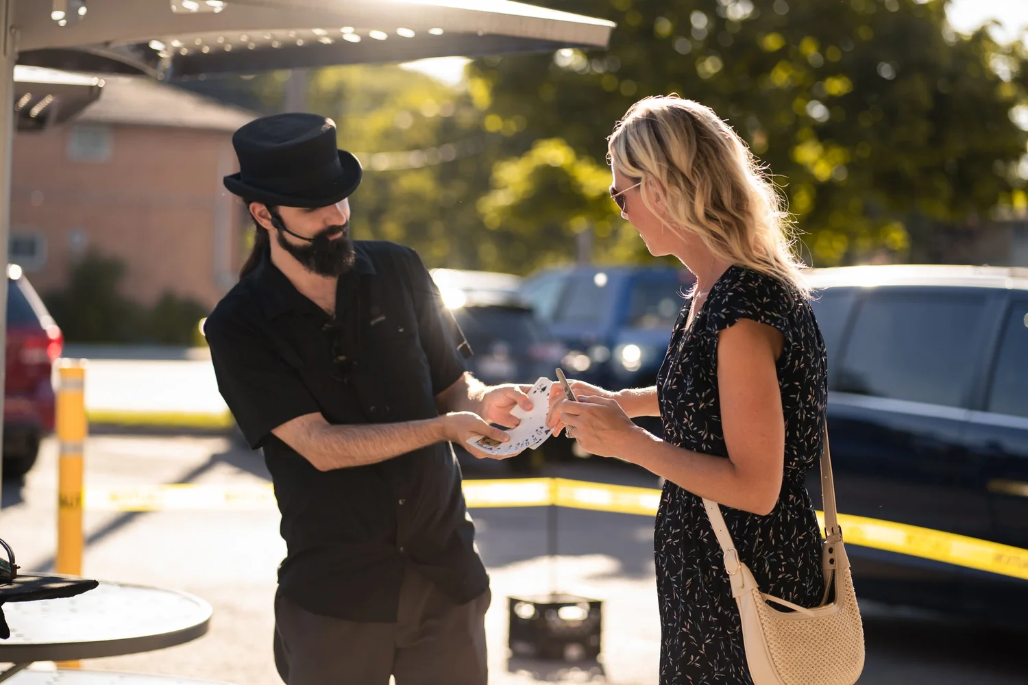 Magician Spencer Scurr performing a close-up card trick for a guest during Magician Weekend at Merla-Mae Ice Cream in London, Ontario