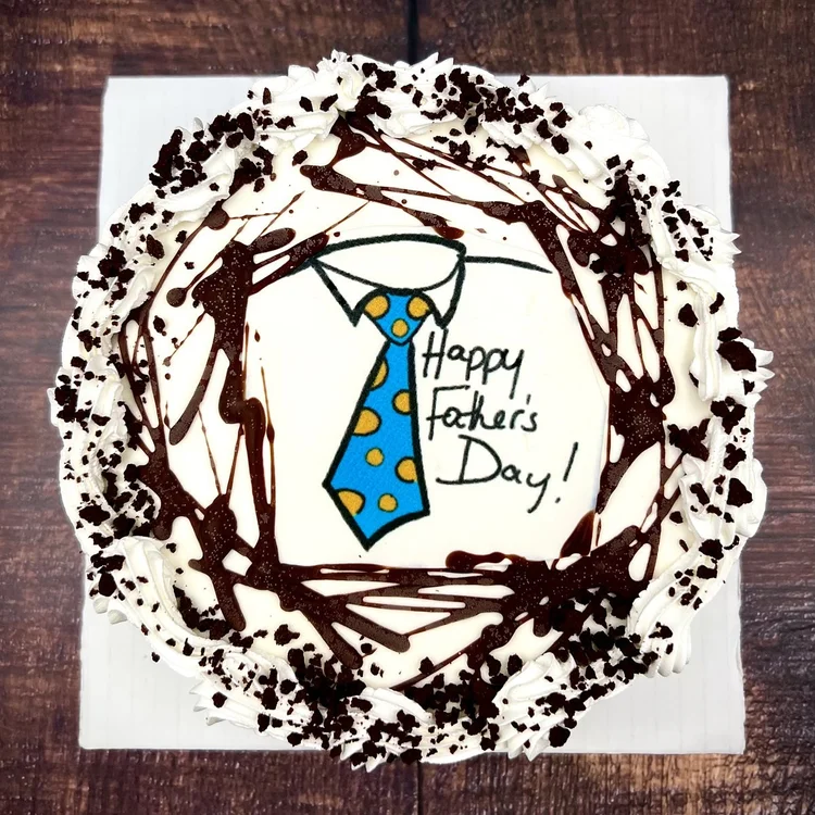 Round Happy Father&rsquo;s Day ice cream cake printed with a blue polka-dot necktie and edged with chocolate drizzle, at Merla-Mae Ice Cream in London, Ontario