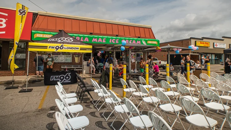FM96 London tent and rows of white chairs in front of the Merla-Mae Ice Cream storefront in London, Ontario, at National Ice Cream Day 2025