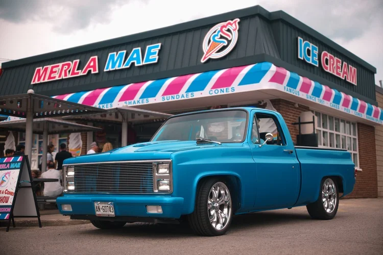 Custom square-body Chevrolet C10 pickup parked outside Merla-Mae Ice Cream at the Chrome & Cones Car Show