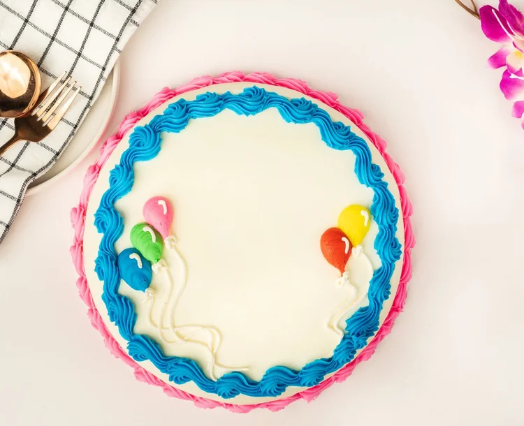 Round white ice cream cake with a blue top border, a pink bottom border and piped balloons at Merla-Mae Ice Cream in London, Ontario