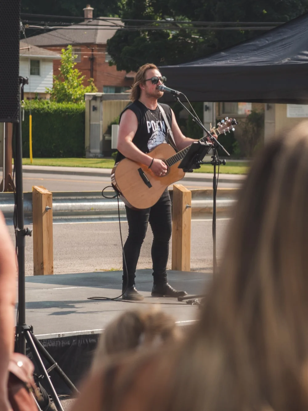 Jason Mercer playing acoustic guitar and singing on the outdoor stage at Merla-Mae Ice Cream in London, Ontario