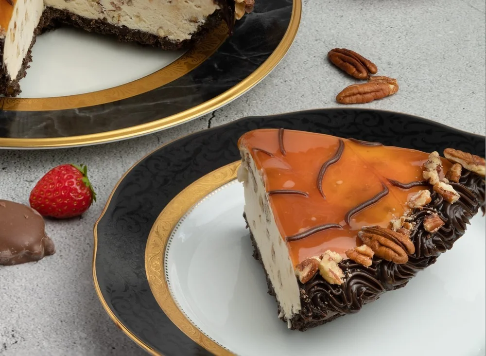 Slice of Turtle ice cream pie with caramel, chocolate and pecans on a gold-rimmed plate at Merla-Mae Ice Cream in London, Ontario