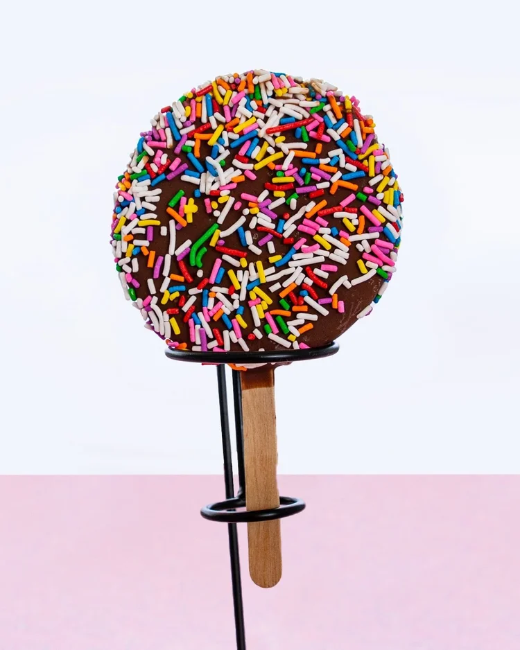 Chocolate-dipped Chillin&rsquo; Bar rolled in rainbow sprinkles on a stand at Merla-Mae Ice Cream in London, Ontario