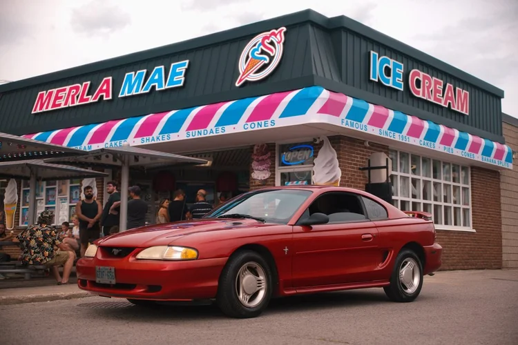 Red 1995 Ford Mustang parked outside Merla-Mae Ice Cream at the Chrome & Cones Car Show