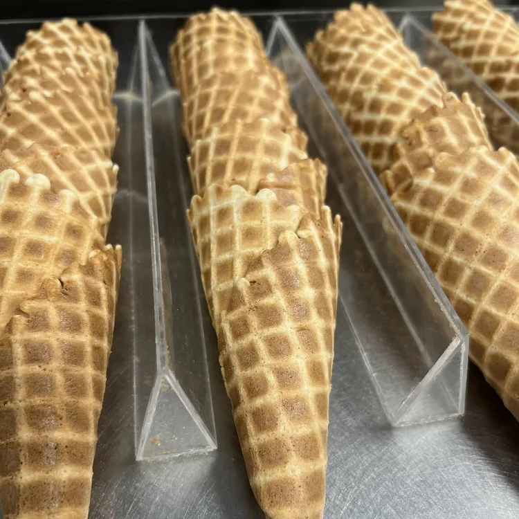 Fresh house-baked waffle cones stacked in cone racks at Merla-Mae Ice Cream in London, Ontario