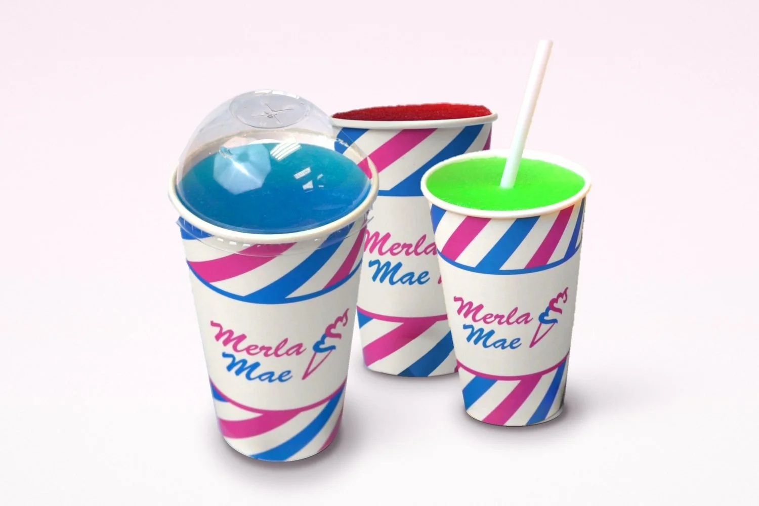 Three slushies in pink and blue striped Merla-Mae cups: blue under a clear dome lid, red, and lime green with a straw, at Merla-Mae Ice Cream in London, Ontario