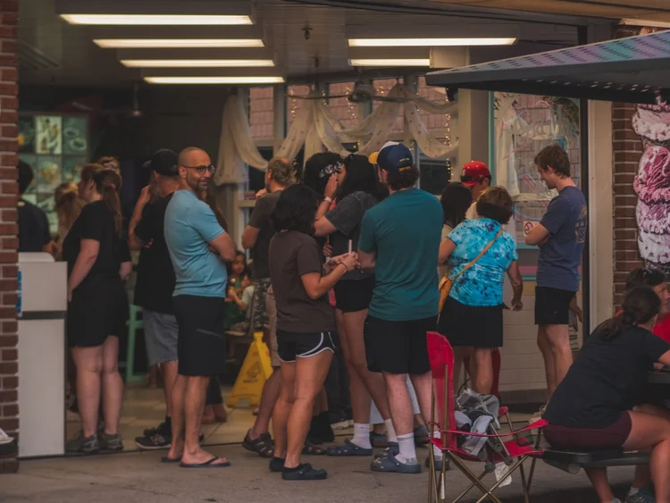Guests lined up at the open front of Merla-Mae Ice Cream on the evening of National Ice Cream Day 2024 in London, Ontario