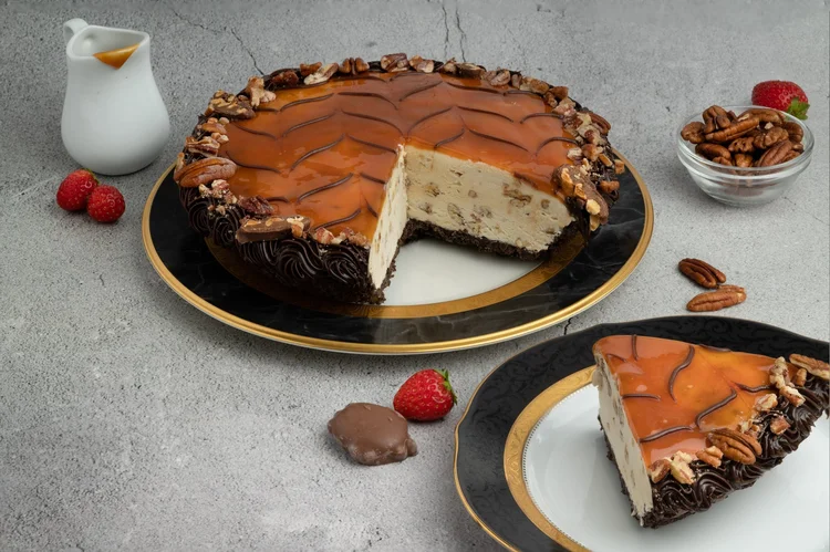 Whole Turtle ice cream pie with a chevron-patterned caramel top, pecans and a chocolate border, one slice cut out, at Merla-Mae Ice Cream in London, Ontario