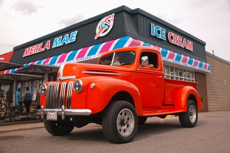 Orange 1947 Ford pickup parked outside Merla-Mae Ice Cream at the Chrome & Cones Car Show