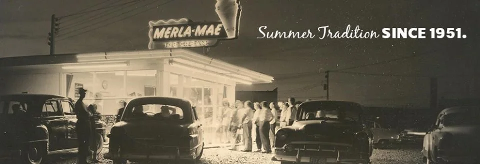Black-and-white photo of customers lined up at the Merla-Mae Ice Cream stand under the banner Summer Tradition since 1951