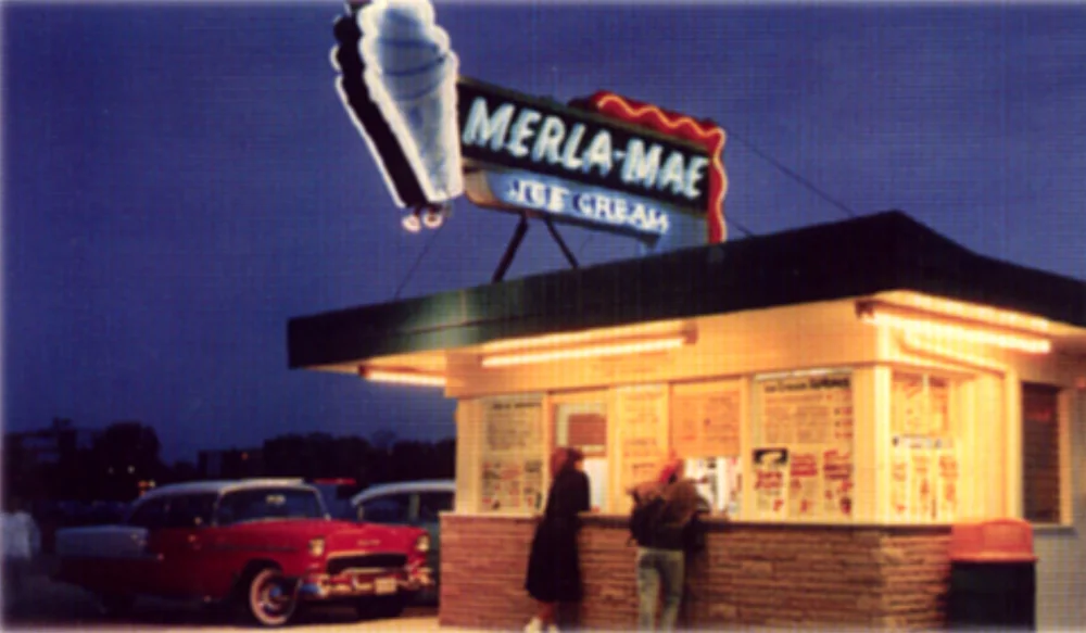 Vintage photo of the Merla-Mae Ice Cream stand glowing at night under its neon cone sign in London, Ontario
