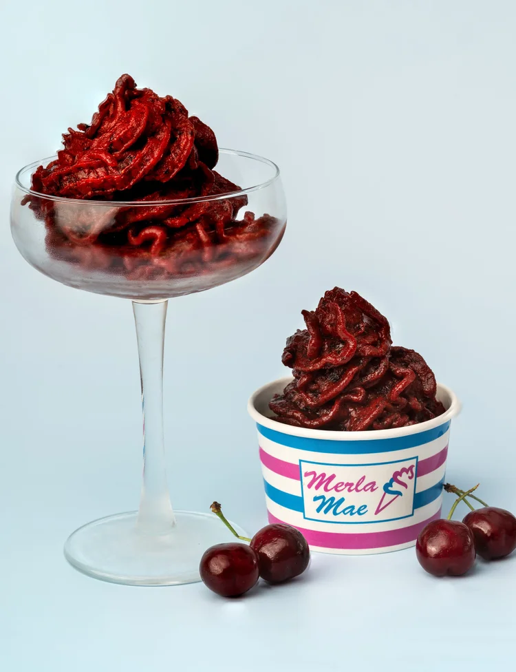 Deep-red cherry pressed fruit in a glass dish and a striped cup, with fresh cherries, at Merla-Mae Ice Cream in London, Ontario