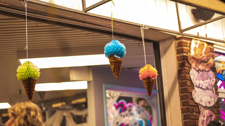Paper ice cream cone decorations hanging at the storefront of Merla-Mae Ice Cream in London, Ontario, for National Ice Cream Day 2025