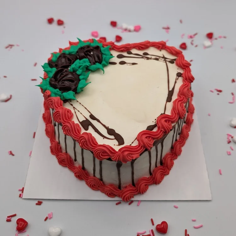 Heart-shaped ice cream cake with dark chocolate icing roses, chocolate drizzle and a red piped border at Merla-Mae Ice Cream in London, Ontario
