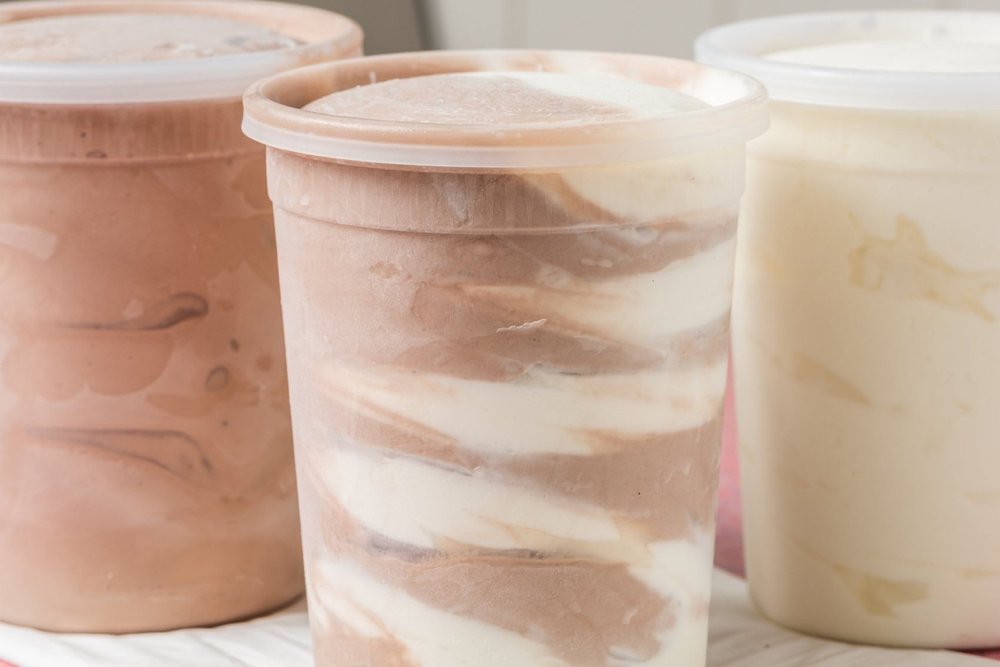Sealed take-home containers of chocolate, twist and vanilla soft-serve at Merla-Mae Ice Cream in London, Ontario