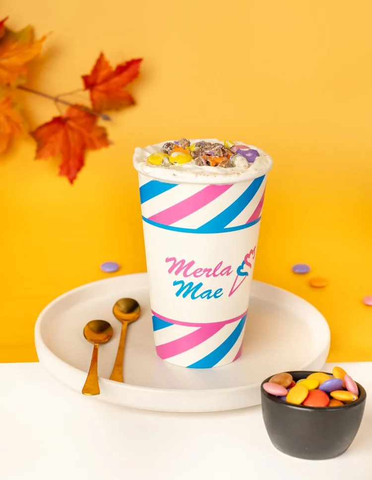 Smarties Cream Shake Flurry topped with candy-coated chocolates in a striped cup at Merla-Mae Ice Cream in London, Ontario