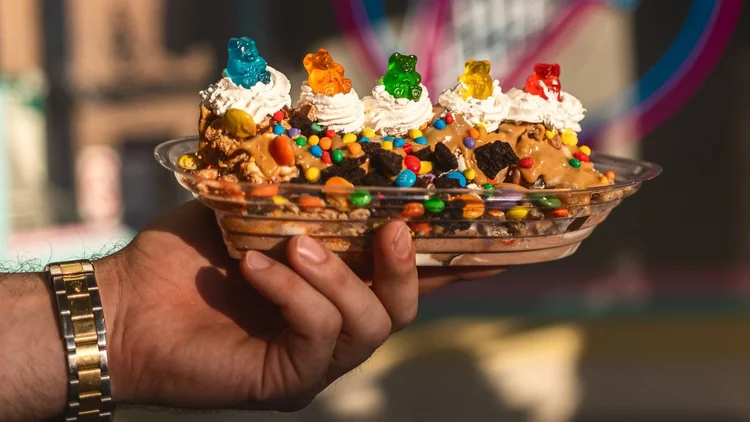 The Tesla Baron sundae topped with whipped cream and gummy bears, held up at Merla-Mae Ice Cream in London, Ontario