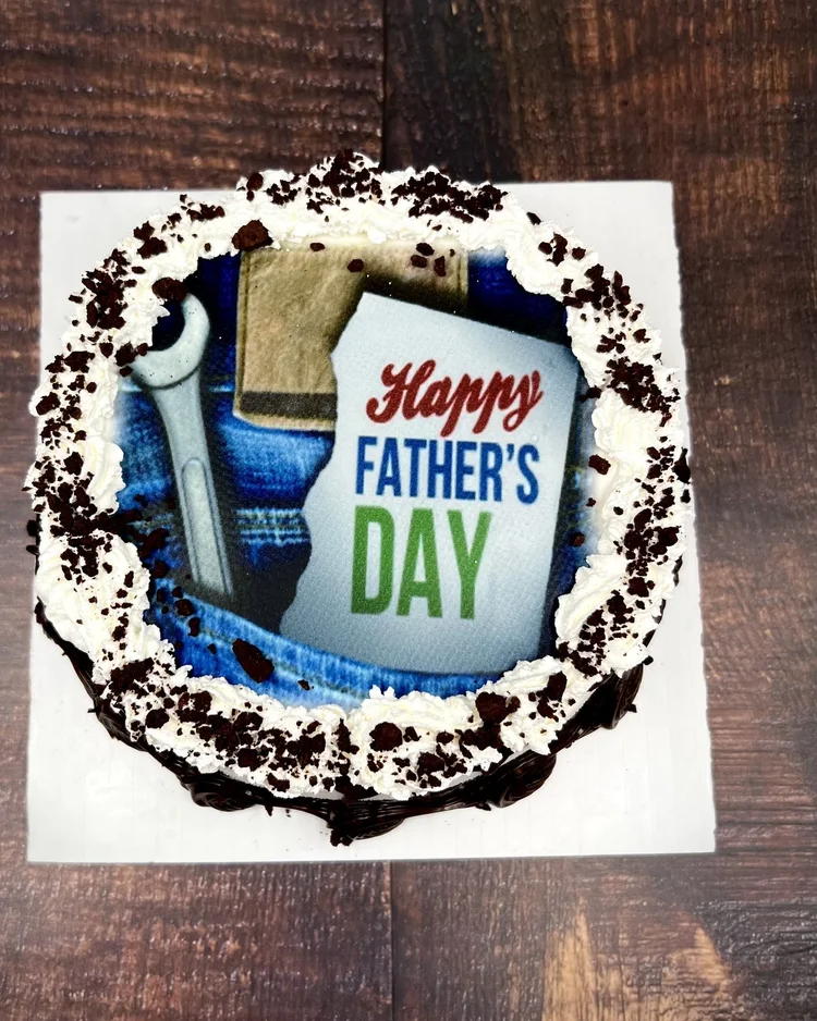 Happy Father&rsquo;s Day photo ice cream cake with a printed wrench-and-denim design and a whipped border with chocolate crumbs, from Merla-Mae Ice Cream in London, Ontario