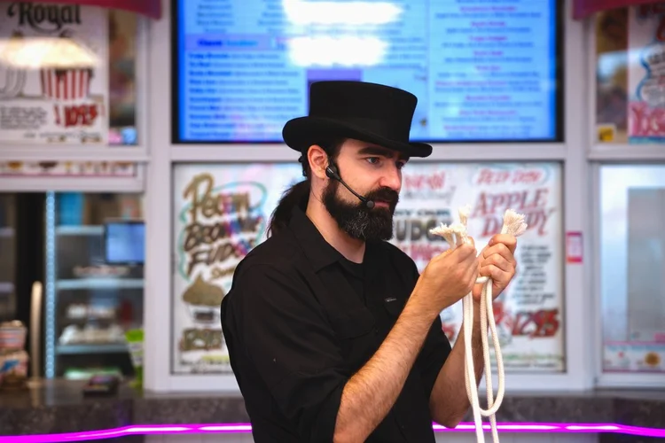Magician tying a rope trick in front of the sundae menu at Merla-Mae Ice Cream in London, Ontario