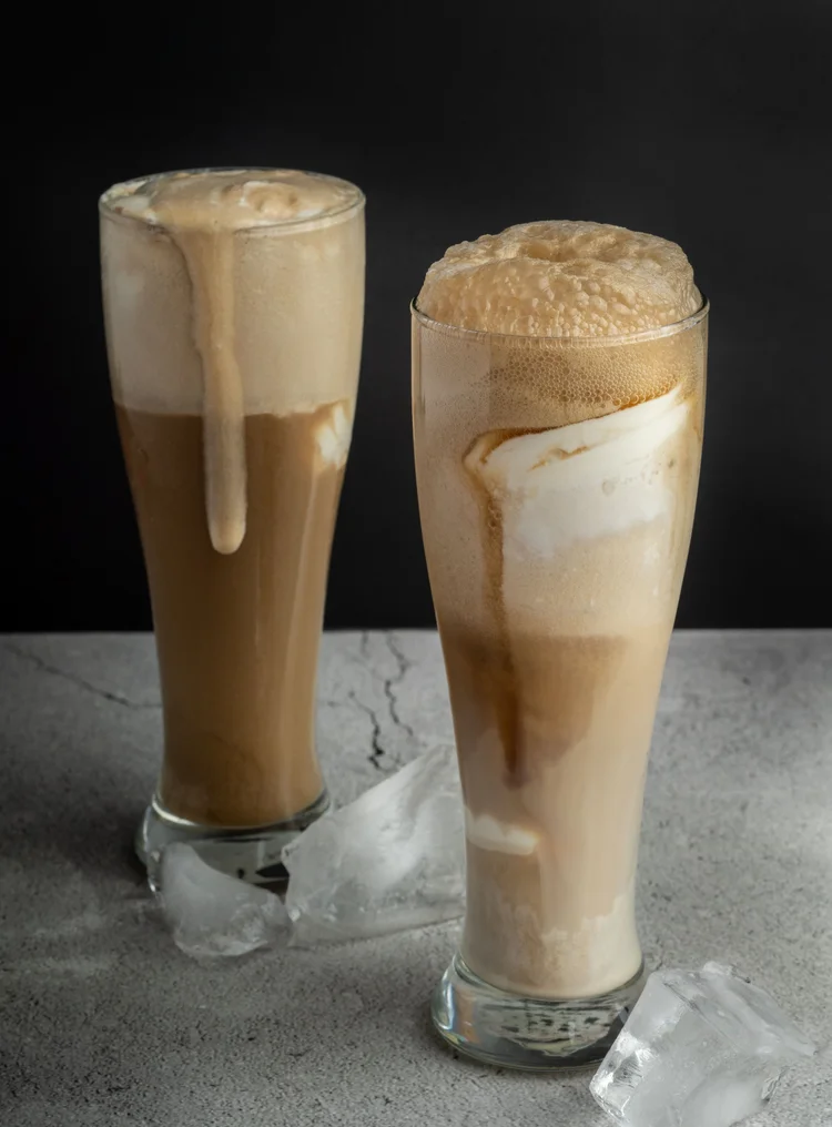 Two ice cream floats with foam spilling down tall glasses at Merla-Mae Ice Cream in London, Ontario