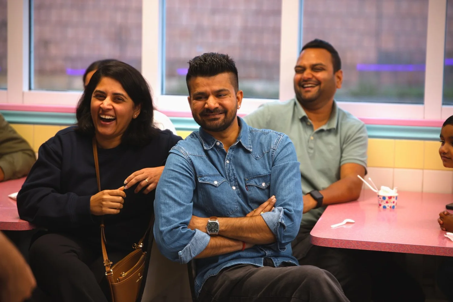 Guests laughing at their table during a magic show at Merla-Mae Ice Cream in London, Ontario