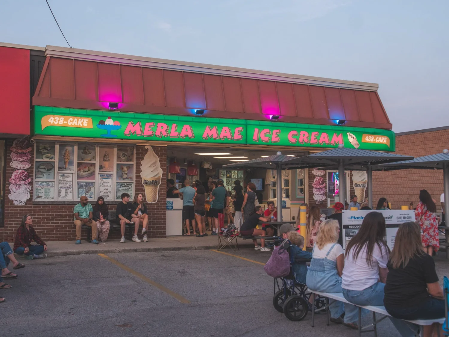 Guests lined up out the door and seated on the patio at dusk during National Ice Cream Day 2024, Merla-Mae Ice Cream in London, Ontario