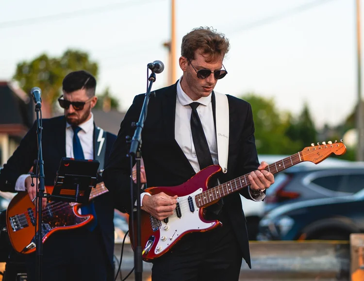 Two Turning Corners guitarists playing side by side at National Ice Cream Day 2025, Merla-Mae Ice Cream in London, Ontario