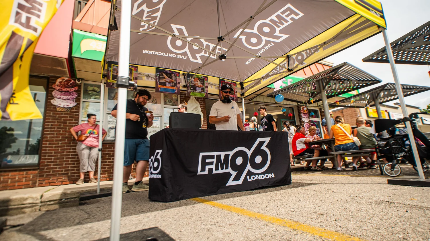 Radio station's live broadcast tent and table set up outside Merla-Mae Ice Cream on National Ice Cream Day in London, Ontario