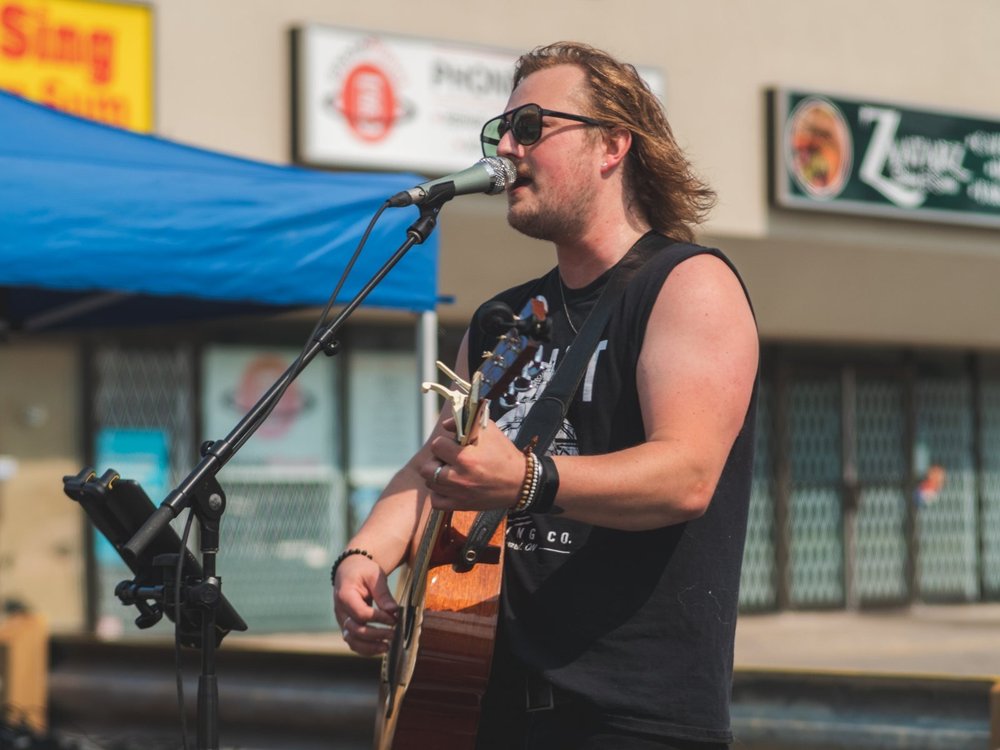 Jason Mercer singing and playing acoustic guitar at National Ice Cream Day 2024, Merla-Mae Ice Cream in London, Ontario
