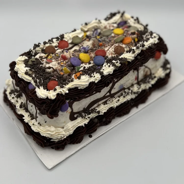 Log-shaped ice cream cake topped with colourful candies, chocolate crumbs and a fudge drizzle at Merla-Mae Ice Cream in London, Ontario