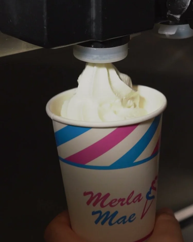 Vanilla soft-serve swirling into a cup of slush under the machine at Merla-Mae Ice Cream in London, Ontario