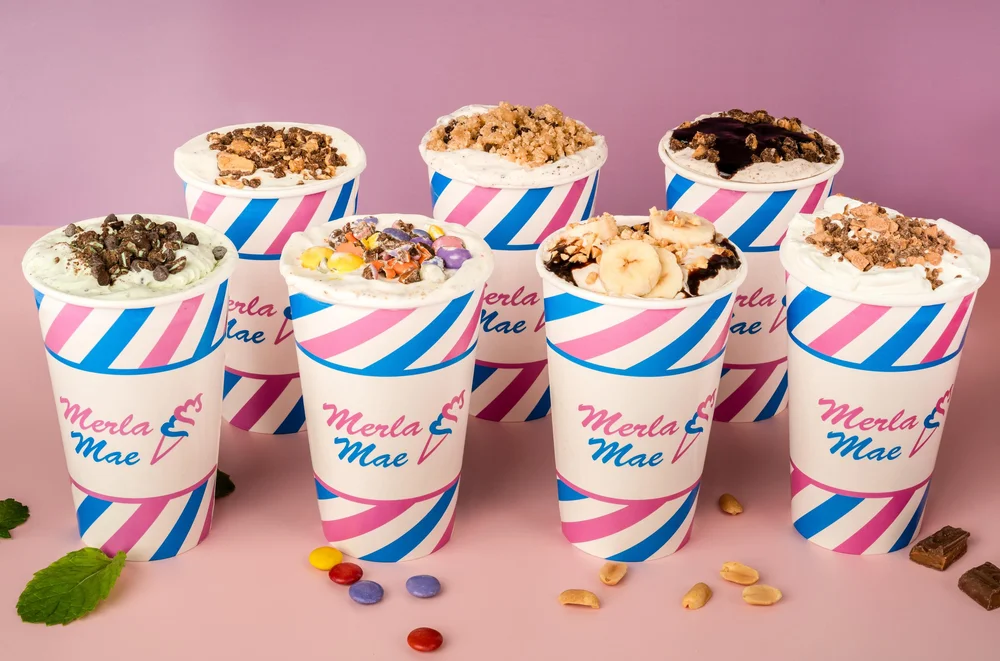 Eight Cream Shake Flurries loaded with cookies, candy, banana and sauces in pink-and-blue striped cups at Merla-Mae Ice Cream in London, Ontario