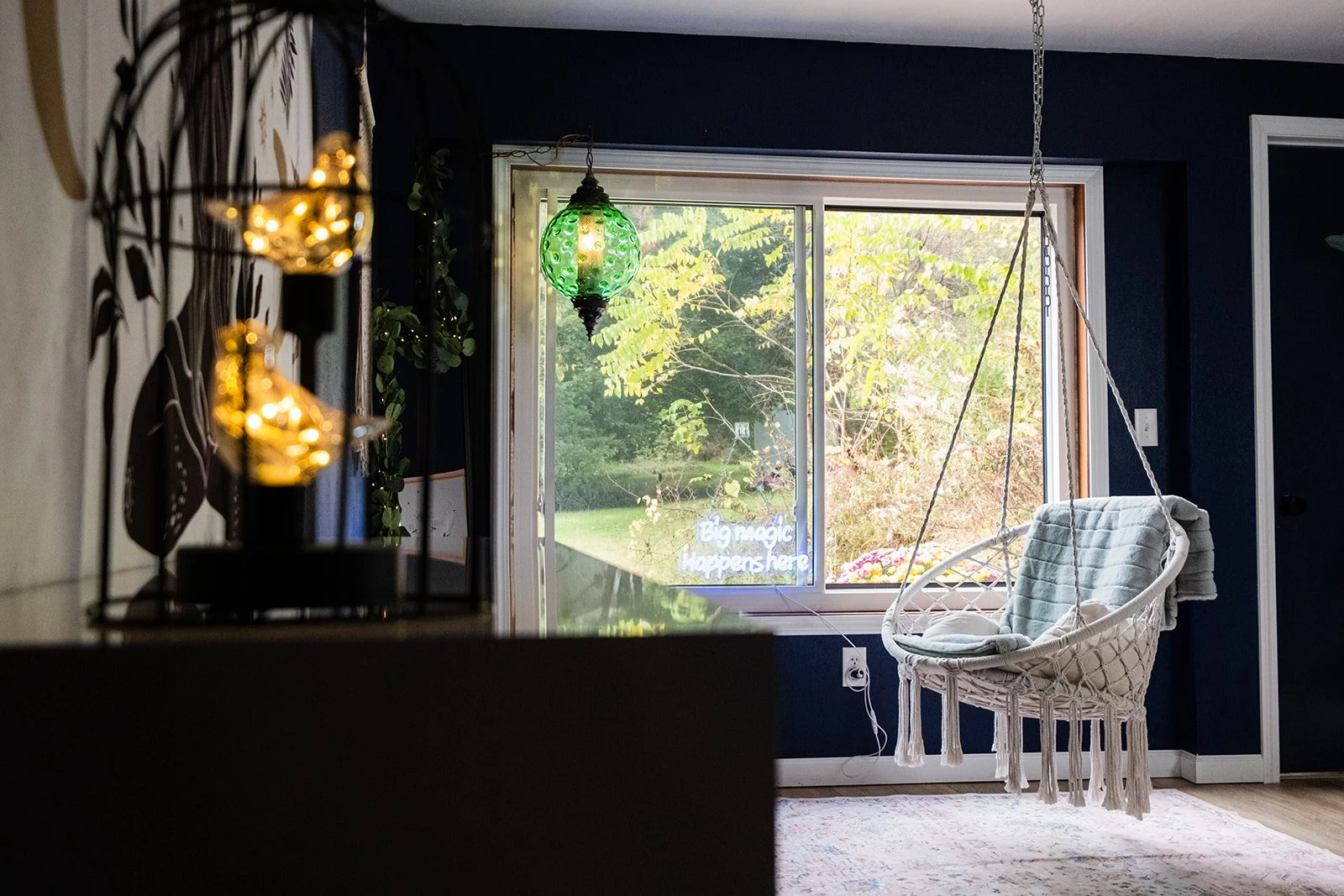 Hanging swing in front of window, lush greenery, antique green light fixture, two birds lamp, cozy, relaxing space