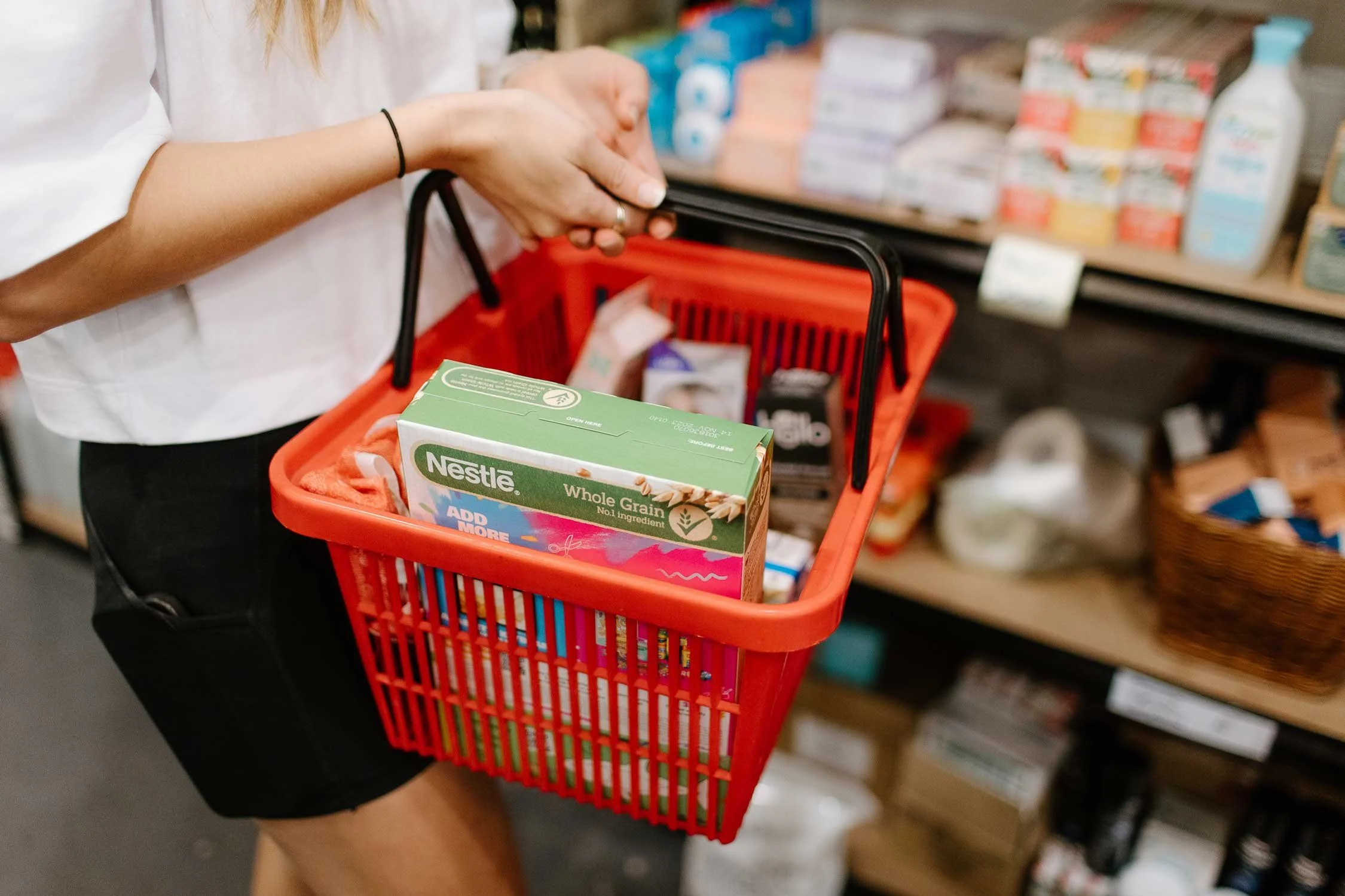 Close up of red shopping basket containing a box of whole grain cereal