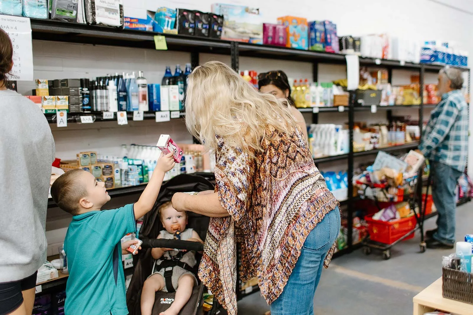 woman handing strawberry milk to kids at Pantry