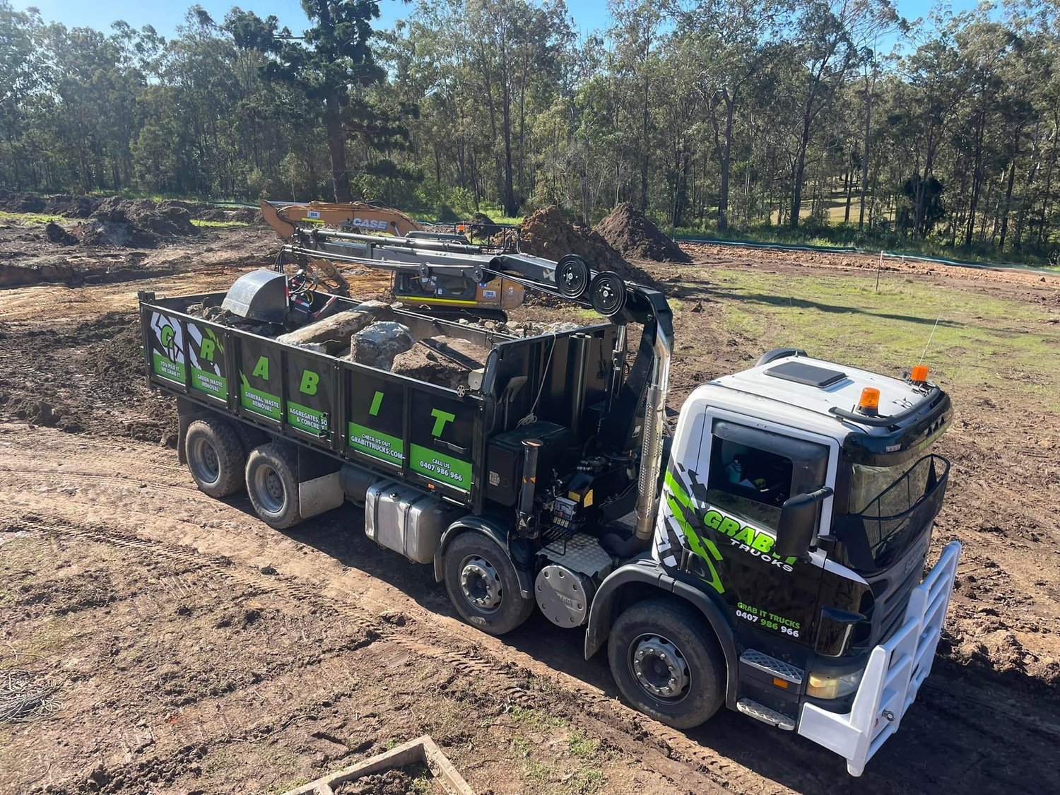 Grab It Trucks grab truck loaded with concrete and soil on a worksite