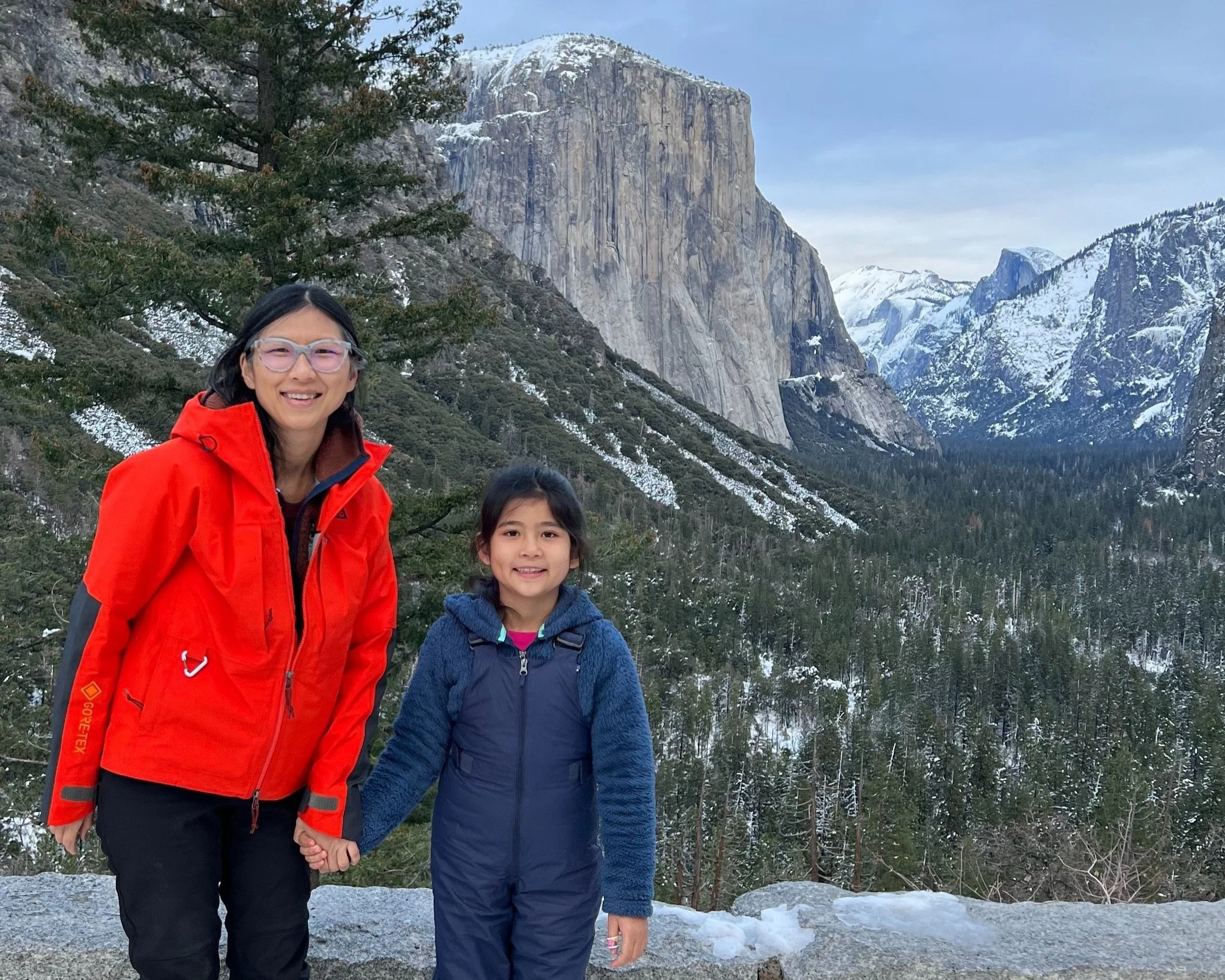 Photo of me and my daughter posing at Tunnel View scenic viewpoint in Yosemite National Park with view of half dome in the background.